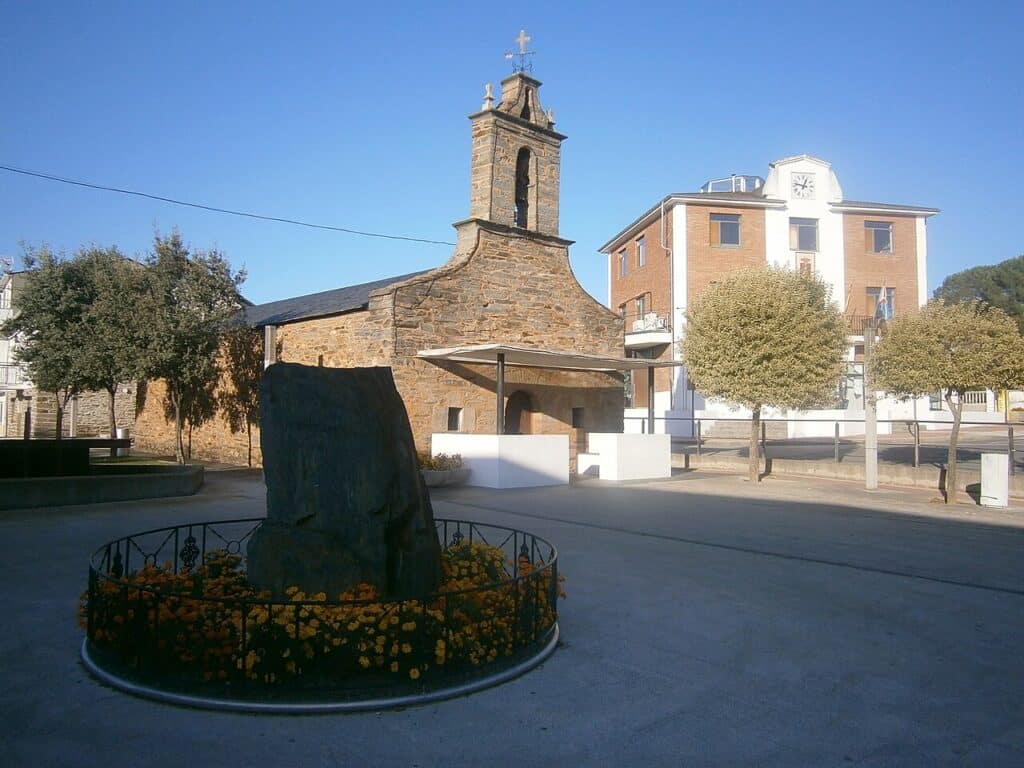 Imagen de la Ermita de San Roque de Cubillos del Sil, con el Ayuntamiento de fondo.