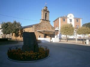 Imagen de la Ermita de San Roque de Cubillos del Sil, con el Ayuntamiento de fondo.