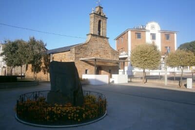 Imagen de la Ermita de San Roque de Cubillos del Sil, con el Ayuntamiento de fondo.
