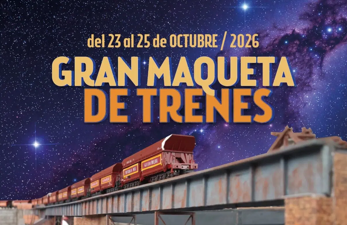 Cartel de la Gran Maqueta de Trenes en La Térmica Cultural, con un tren de tolvas cruzando un puente metálico bajo un cielo estrellado